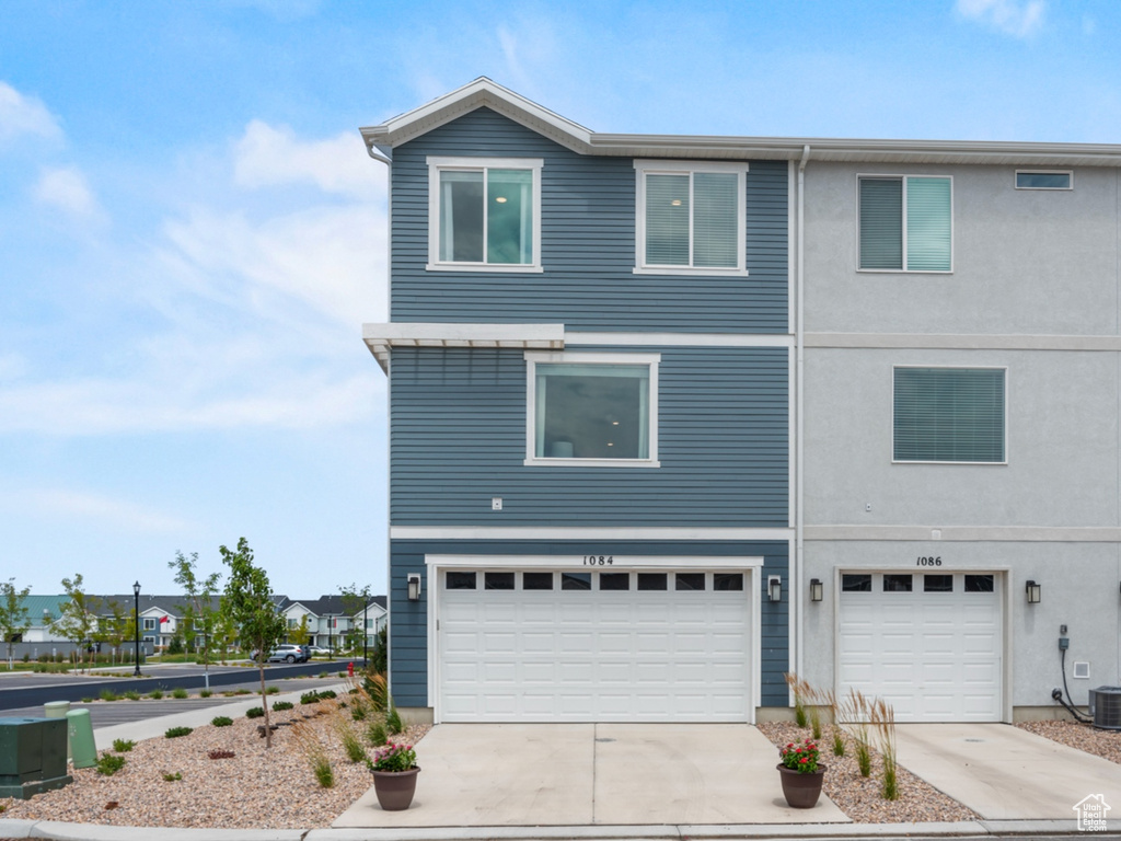 View of front of property featuring concrete driveway and a garage