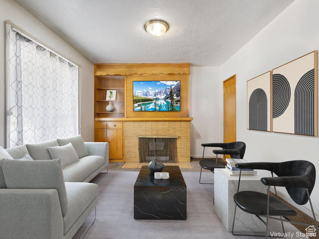Carpeted living room featuring a fireplace and a textured ceiling
