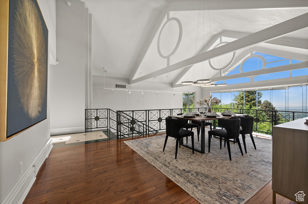 Dining room with high vaulted ceiling and wood finished floors