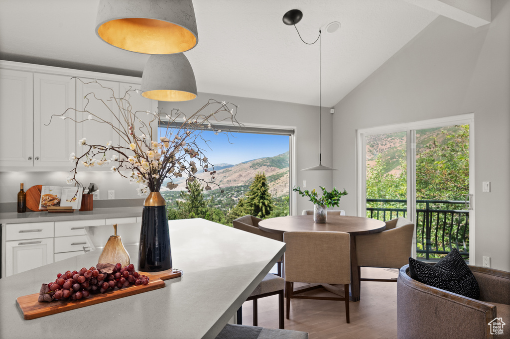 Dining space with vaulted ceiling, wood finished floors, and a mountain view