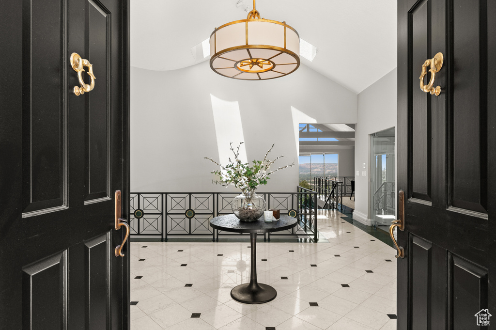 Entrance foyer featuring high vaulted ceiling and light tile patterned floors