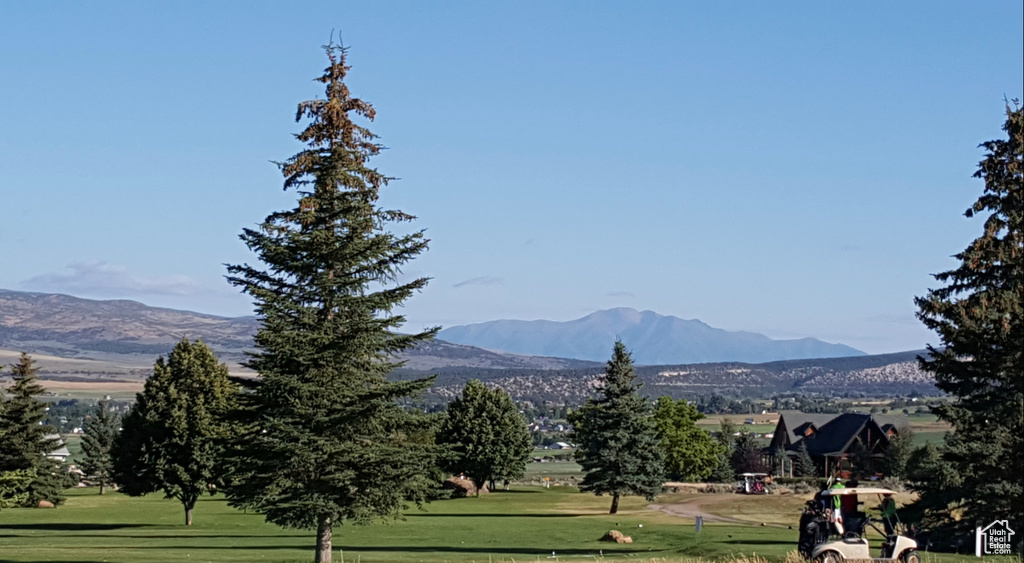 View of property's community featuring a lawn, a mountain view, and golf course view