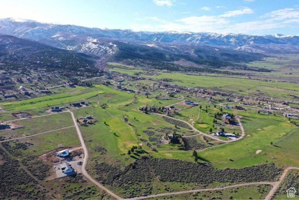 Aerial view of property and surrounding area featuring a mountainous background