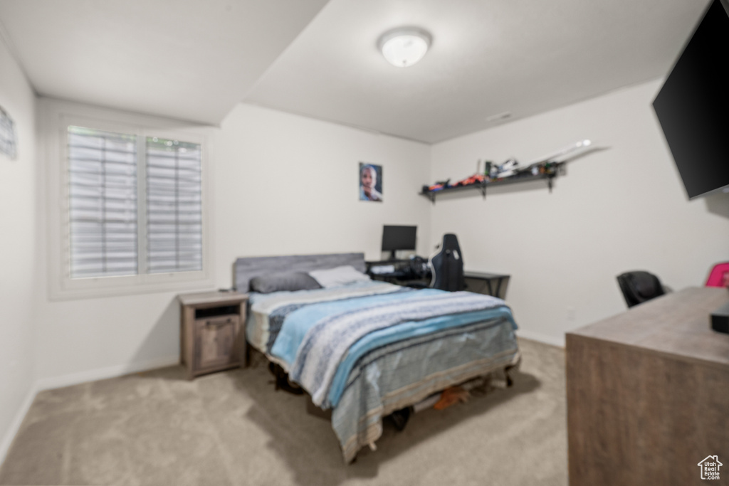 Bedroom featuring light colored carpet and an office area
