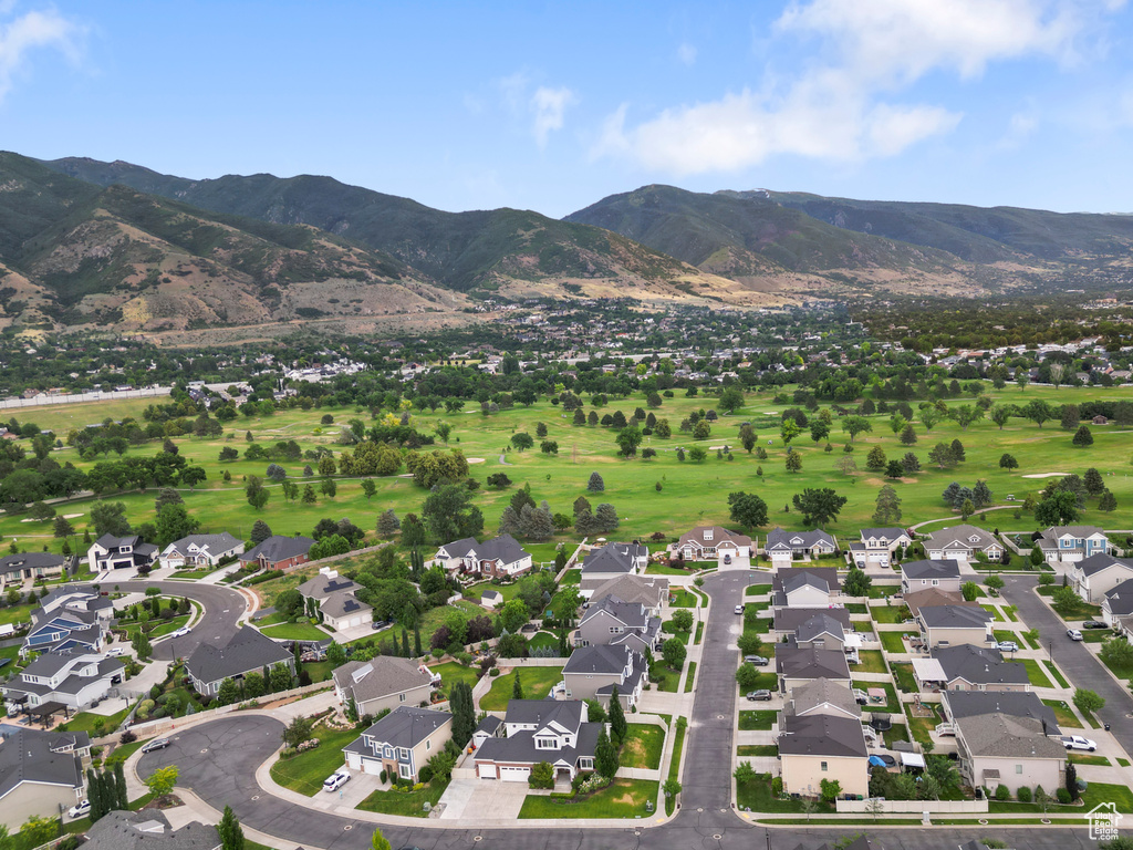 Aerial view of property and surrounding area with nearby suburban area and a mountain backdrop