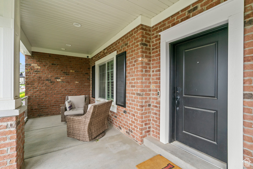 Property entrance with covered porch and brick siding