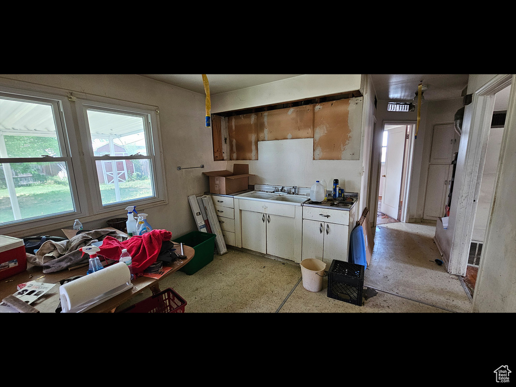 Kitchen featuring a sink and white cabinetry