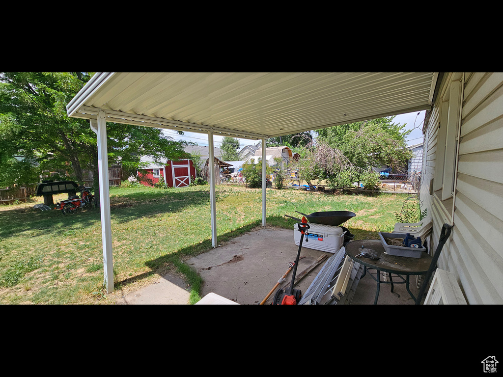 Fenced backyard featuring a patio and a storage shed