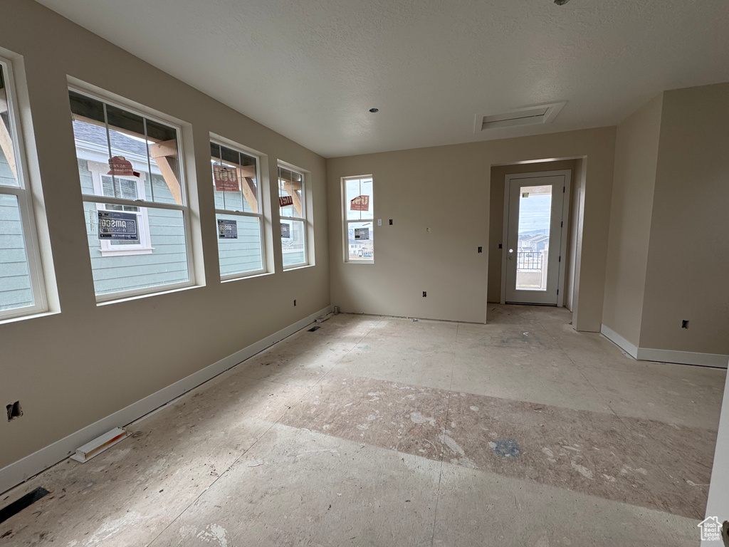 Unfurnished room with baseboards and attic access