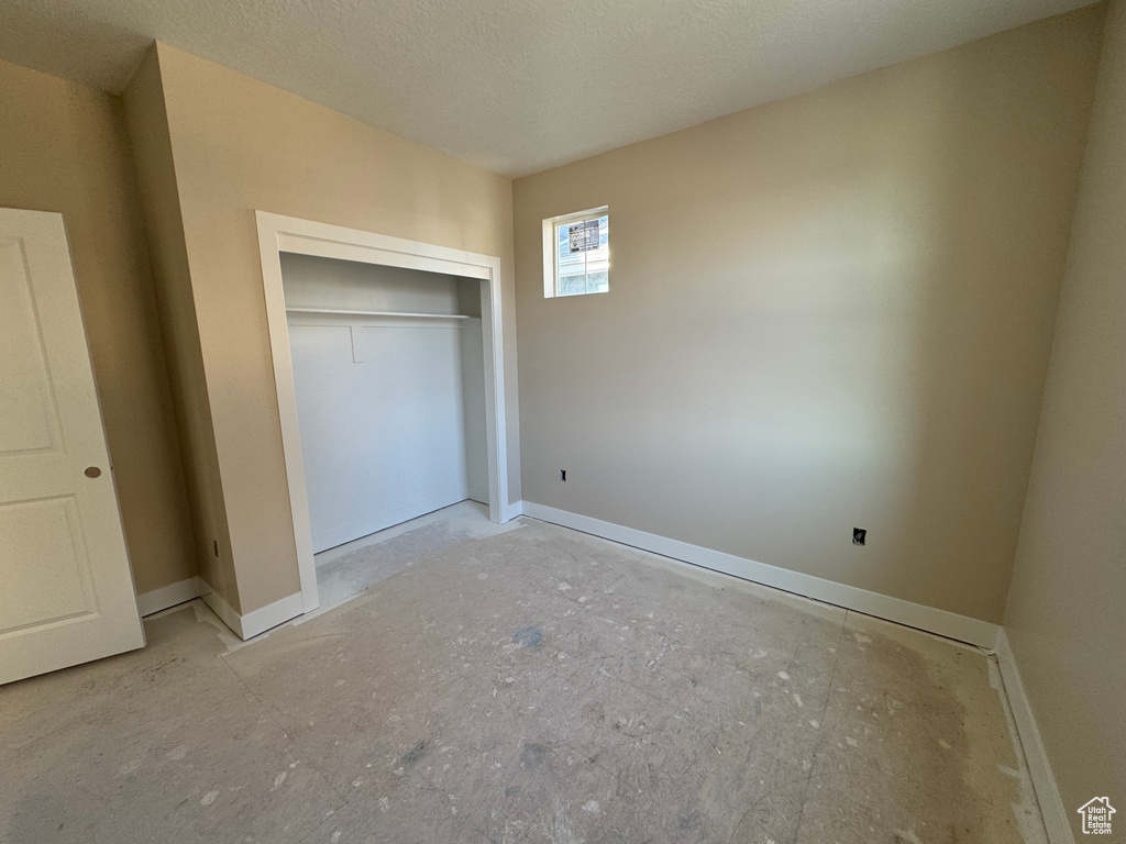 Unfurnished bedroom featuring a closet and baseboards