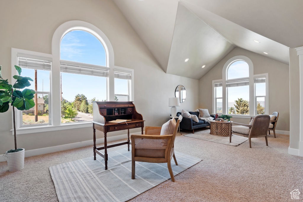 Living area with carpet, high vaulted ceiling, and recessed lighting
