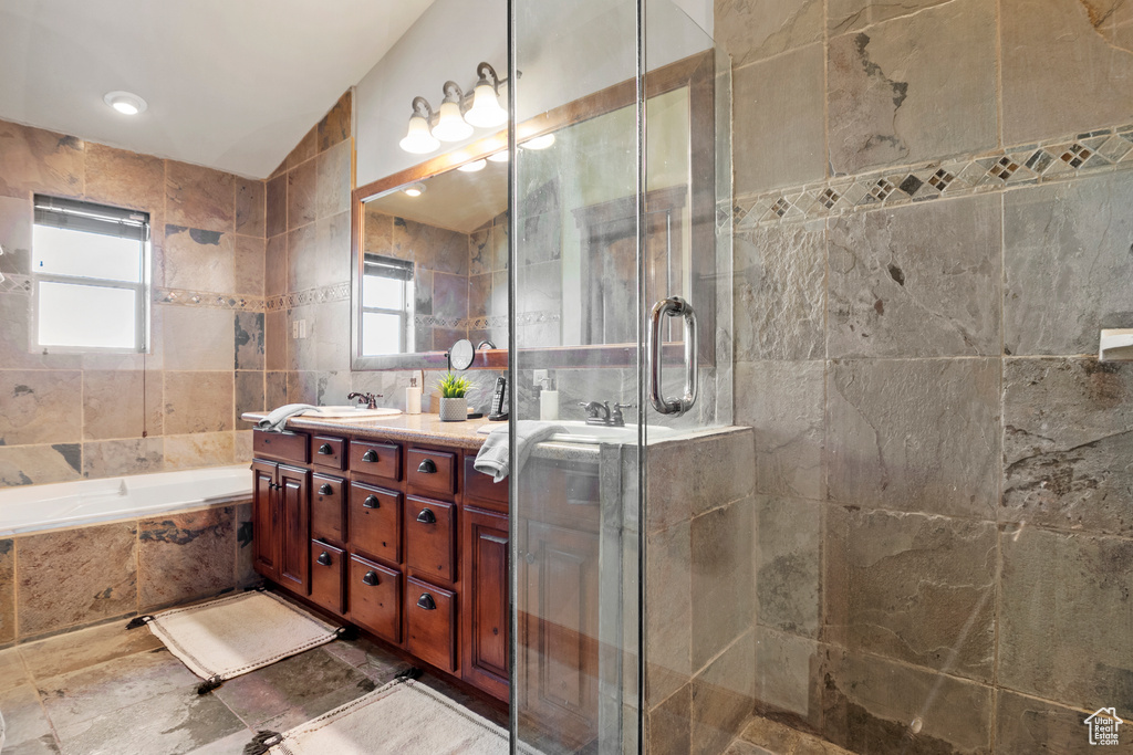 Bathroom featuring vanity, tile walls, a shower stall, and a bath