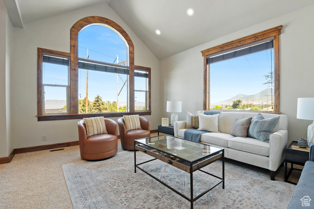 Carpeted living area with a mountain view, recessed lighting, and high vaulted ceiling