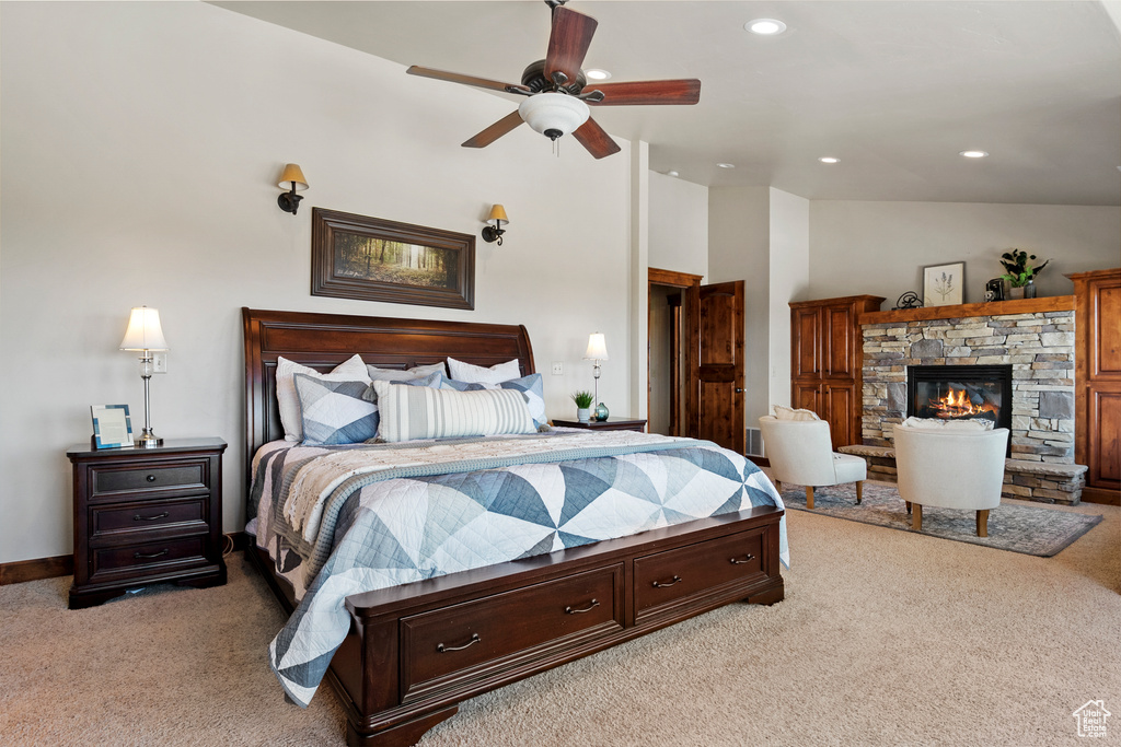 Bedroom with light carpet, vaulted ceiling, a fireplace, recessed lighting, and a ceiling fan