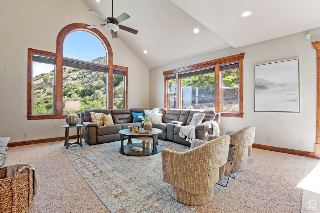 Carpeted living area featuring high vaulted ceiling, recessed lighting, and a ceiling fan
