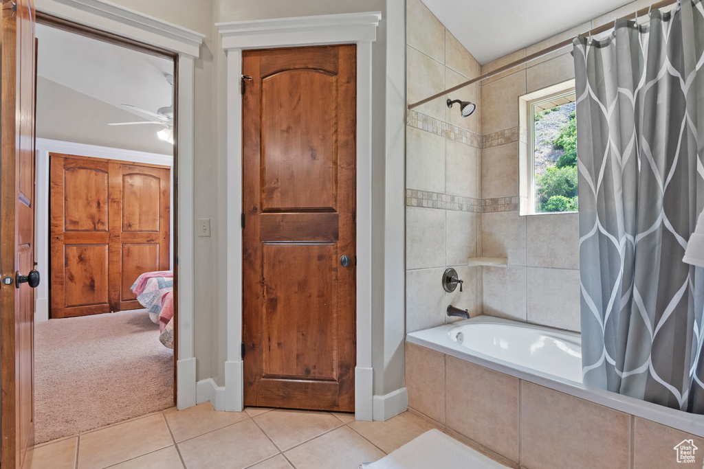 Ensuite bathroom with tiled shower / bath, tile patterned floors, and a ceiling fan
