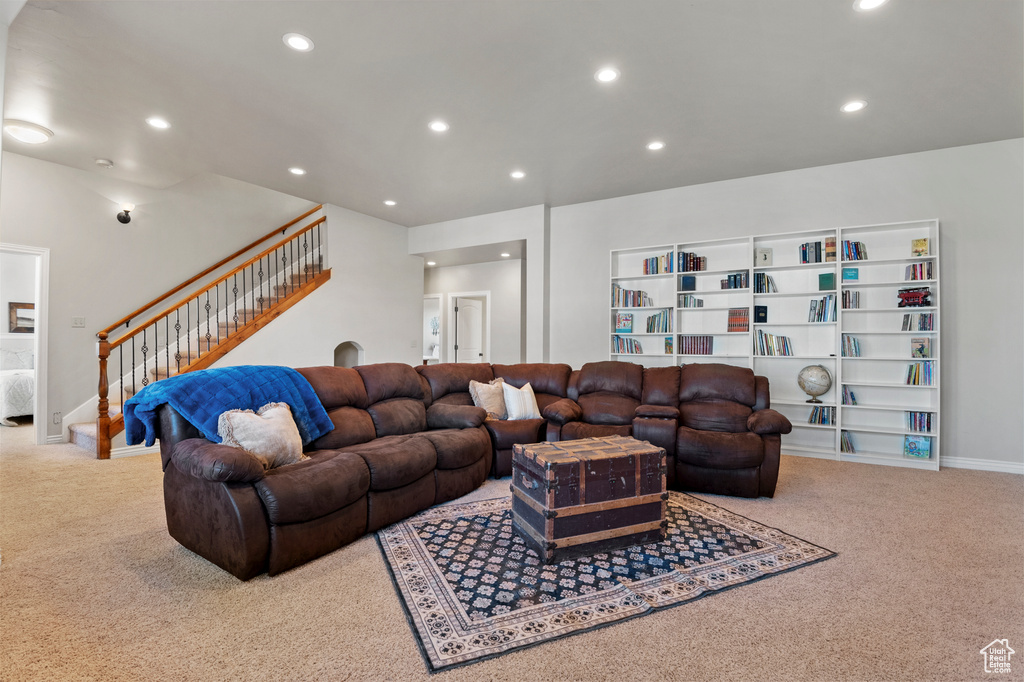 Carpeted living area with stairway and recessed lighting