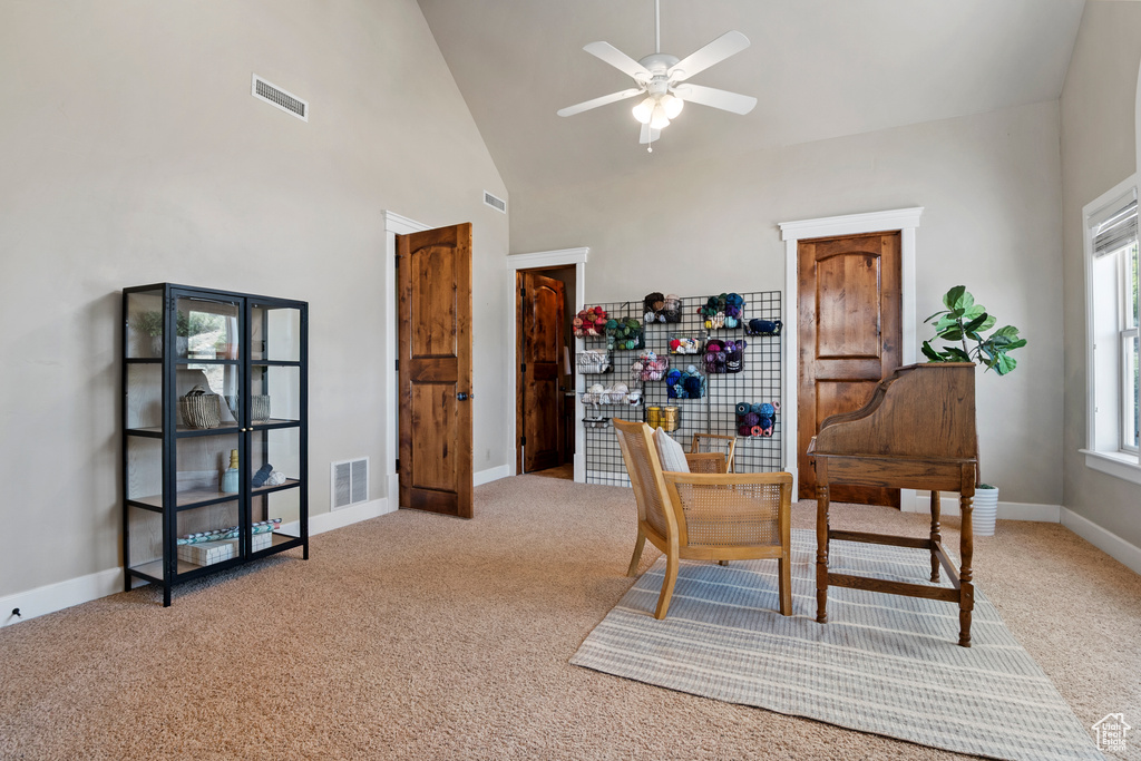 Carpeted home office featuring a ceiling fan and high vaulted ceiling