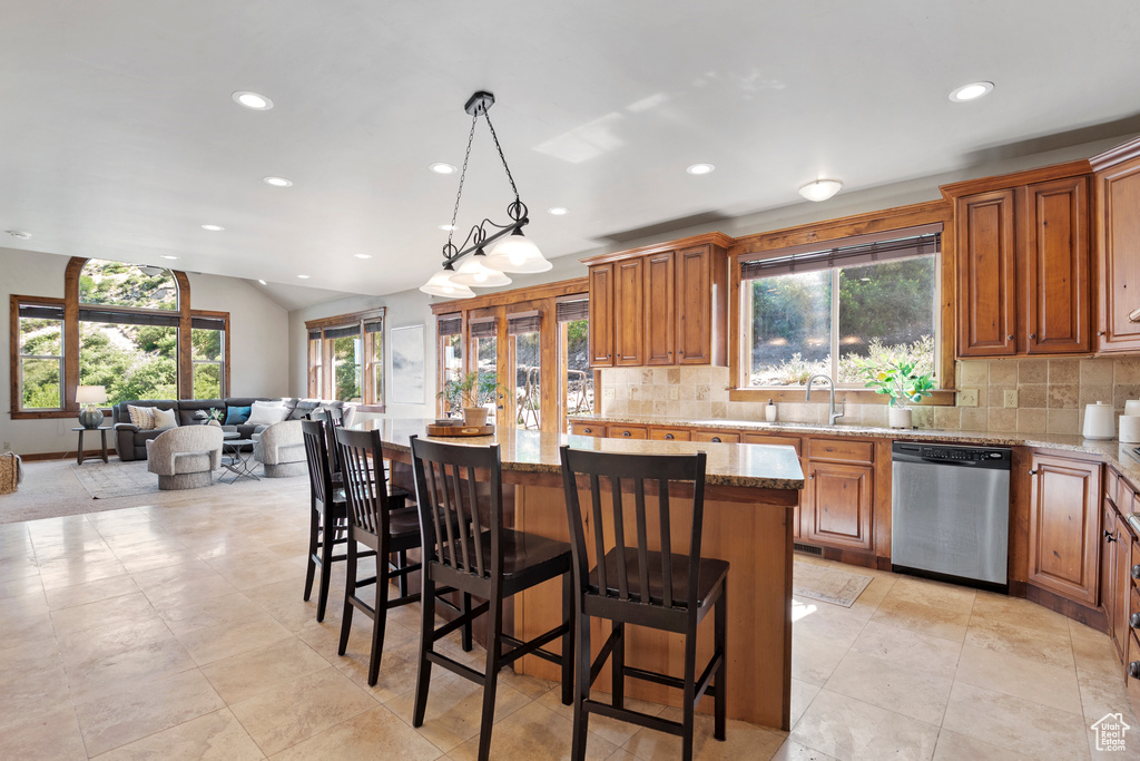 Kitchen with stainless steel dishwasher, recessed lighting, a kitchen island, healthy amount of natural light, and backsplash