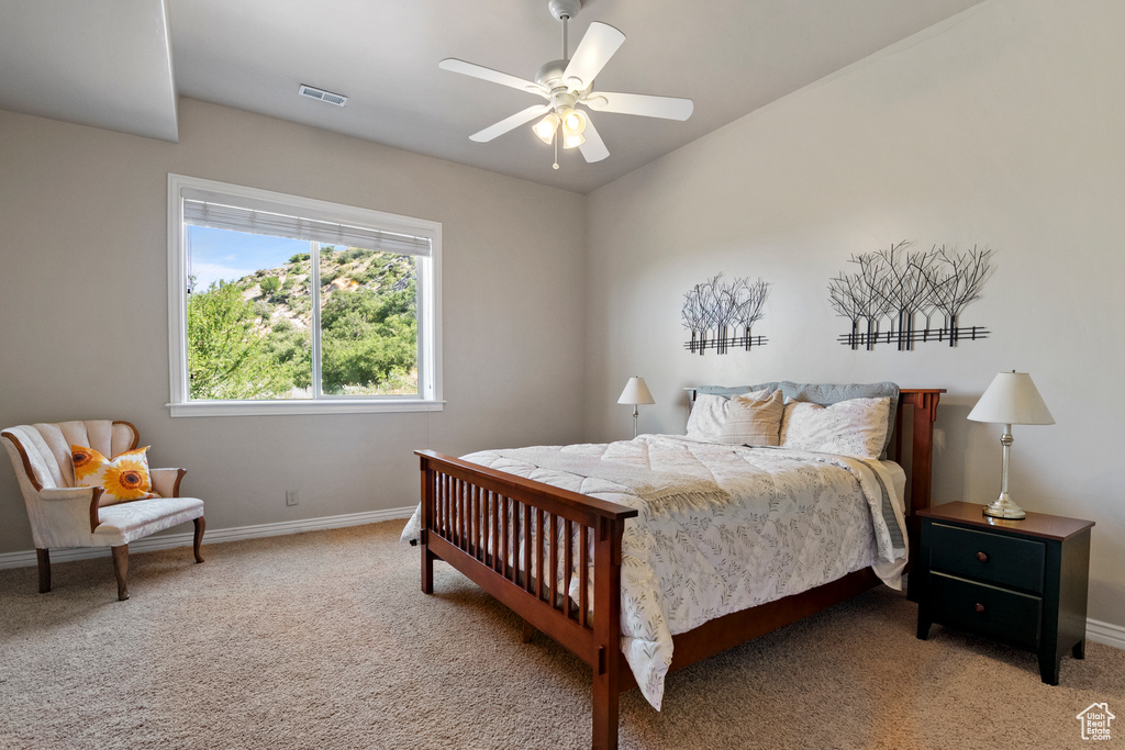 Carpeted bedroom with baseboards and a ceiling fan