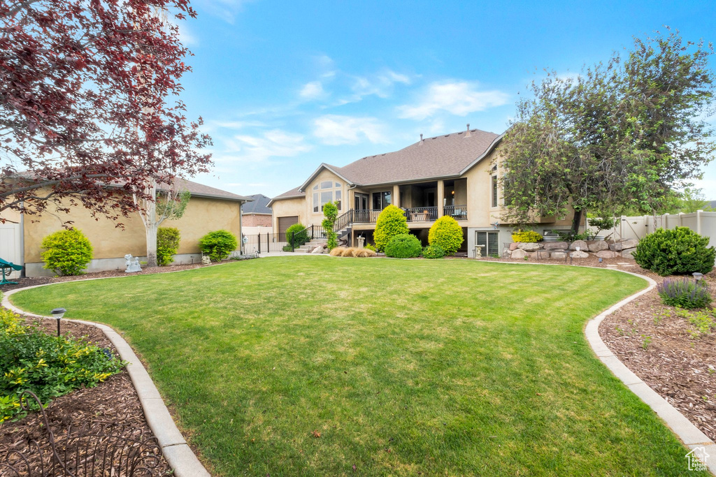 View of front of home with stucco siding, a fenced backyard, and stairs