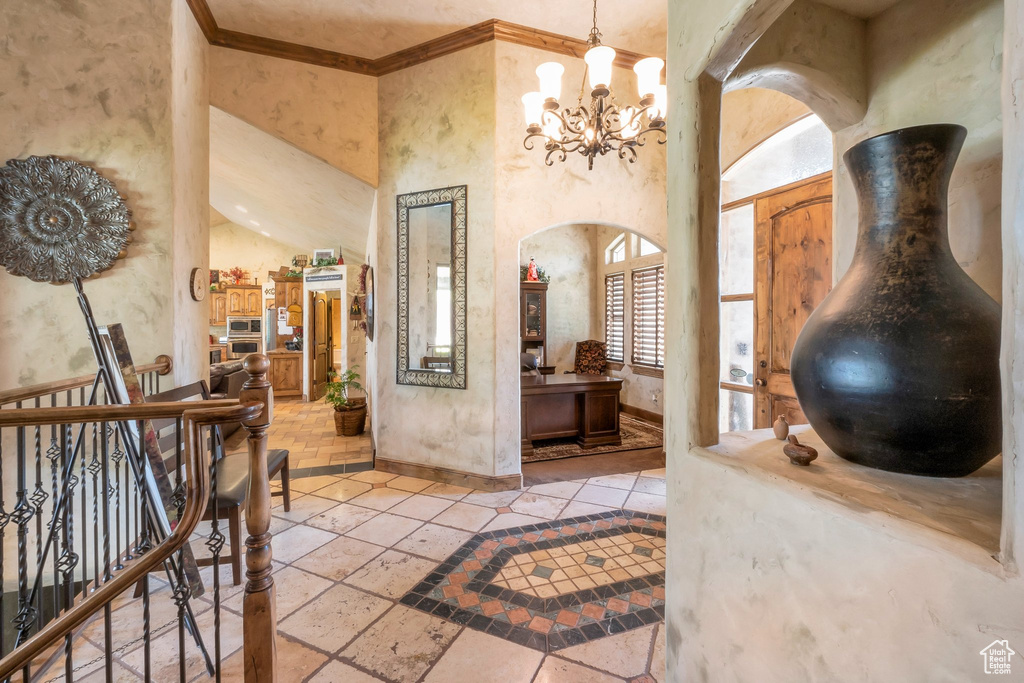 Entrance foyer with a chandelier and crown molding