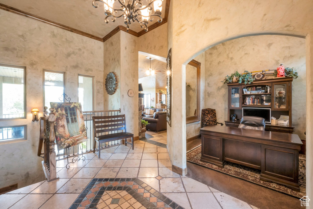 Home office with healthy amount of natural light, arched walkways, ornamental molding, inlaid floor details, and a chandelier