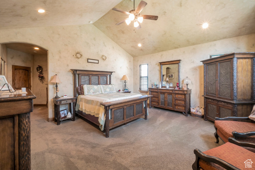 Bedroom featuring light colored carpet, vaulted ceiling, arched walkways, recessed lighting, and ceiling fan