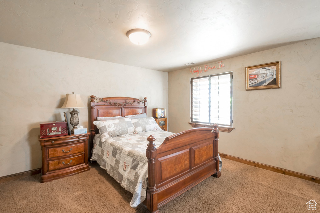 Bedroom featuring carpet and baseboards