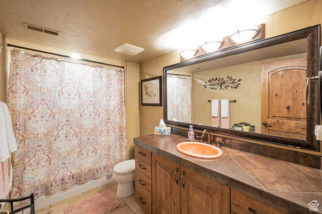 Bathroom featuring vanity, tile patterned flooring, and shower / bath combo
