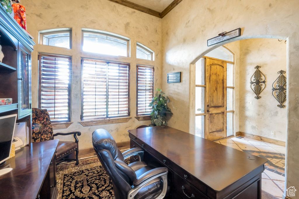 Home office with crown molding, arched walkways, and tile patterned flooring