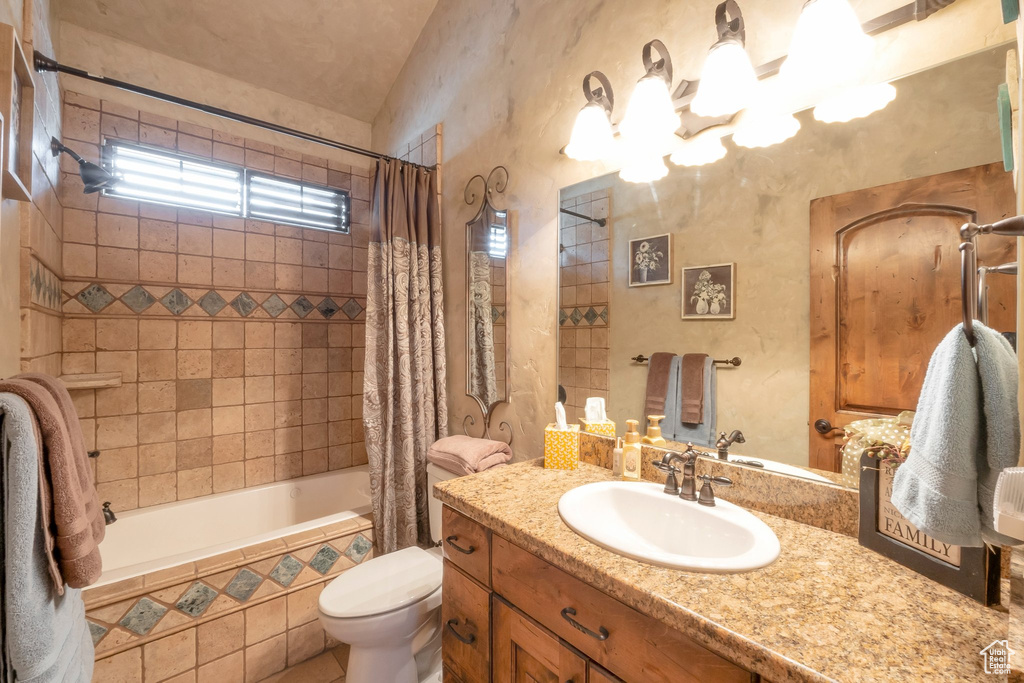 Bathroom with tiled shower / bath, vanity, and a chandelier