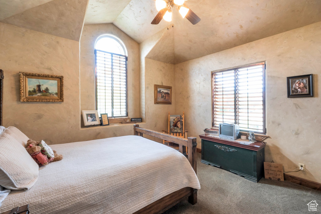 Bedroom featuring multiple windows, lofted ceiling, carpet flooring, and ceiling fan