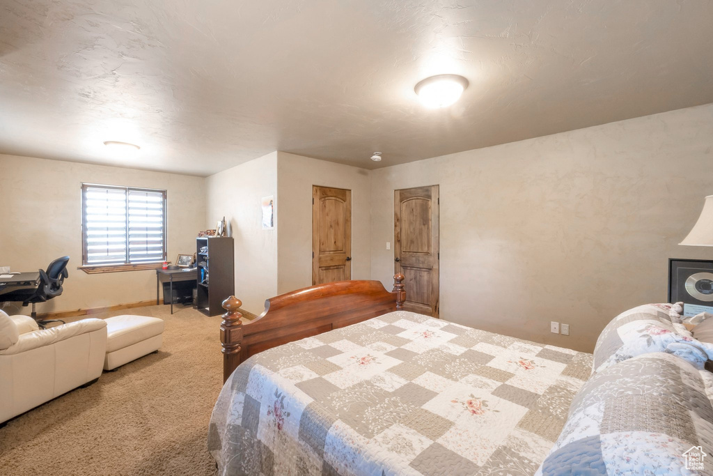 Carpeted bedroom with a desk