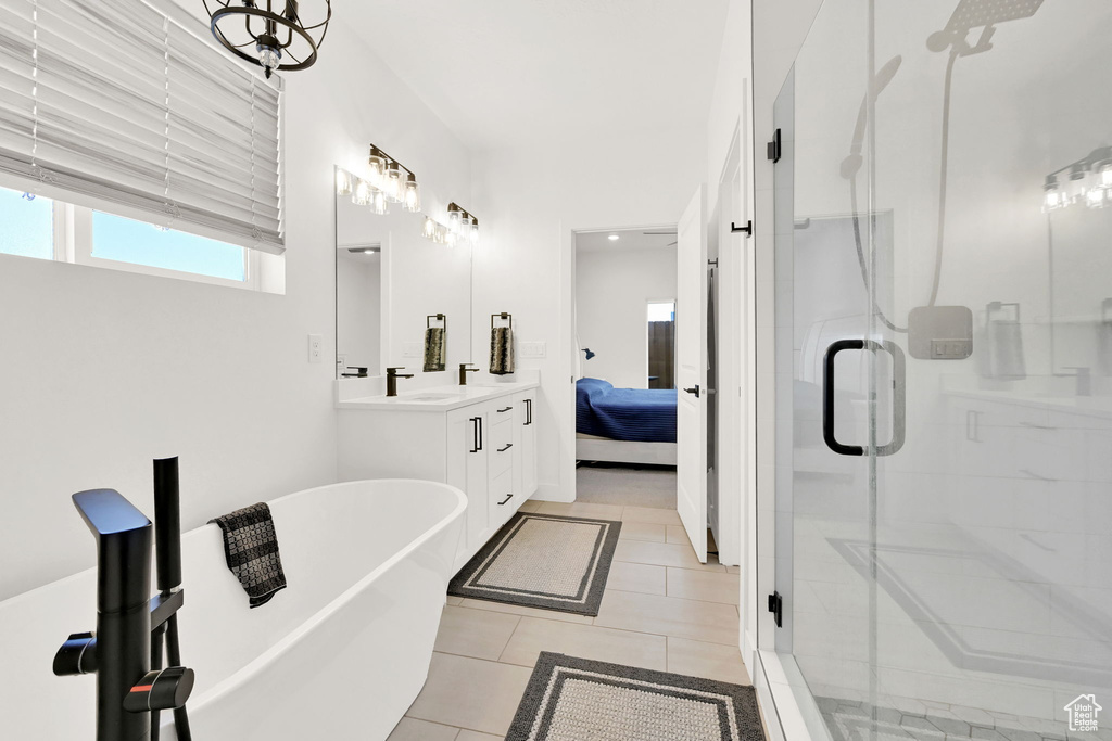 Ensuite bathroom with a stall shower, double vanity, a freestanding bath, and tile patterned floors