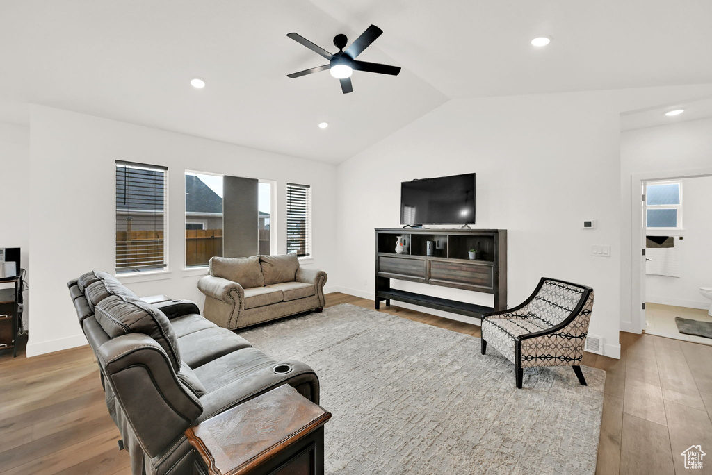 Living room featuring vaulted ceiling, a ceiling fan, wood finished floors, and recessed lighting