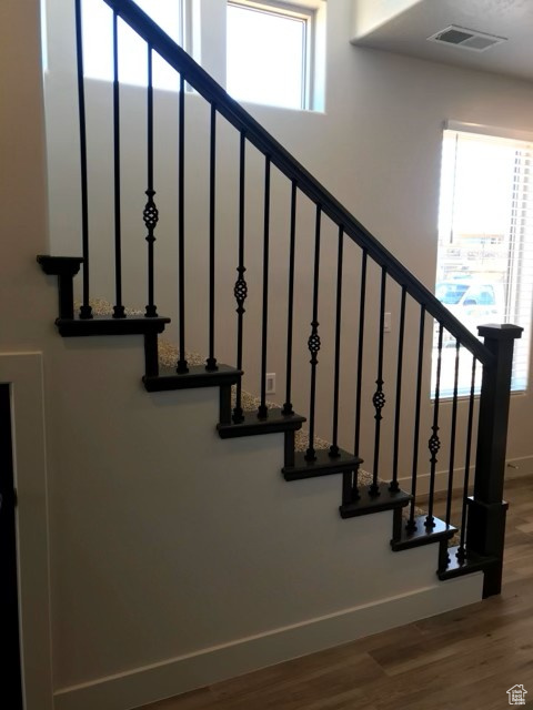 Staircase featuring wood finished floors and baseboards