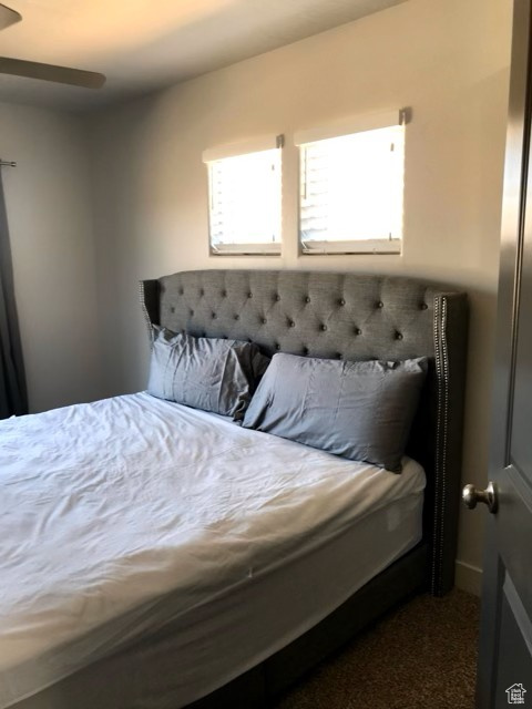 Bedroom featuring dark carpet and a ceiling fan