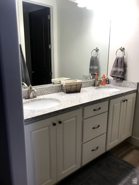 Bathroom featuring double vanity and wood finished floors