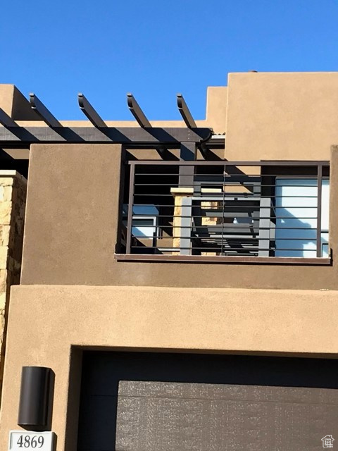 View of side of property with a balcony and stucco siding