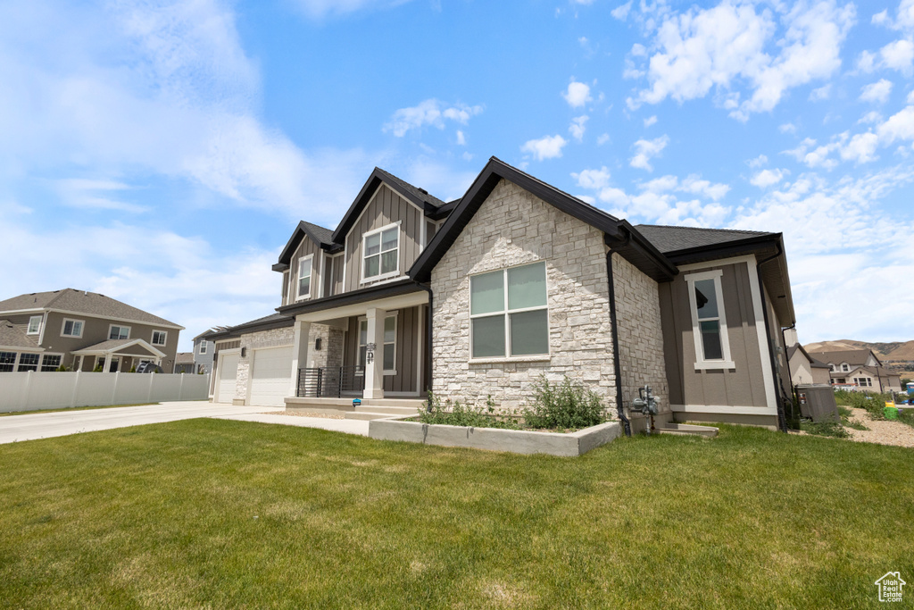 Craftsman inspired home featuring concrete driveway, board and batten siding, stone siding, an attached garage, and a residential view