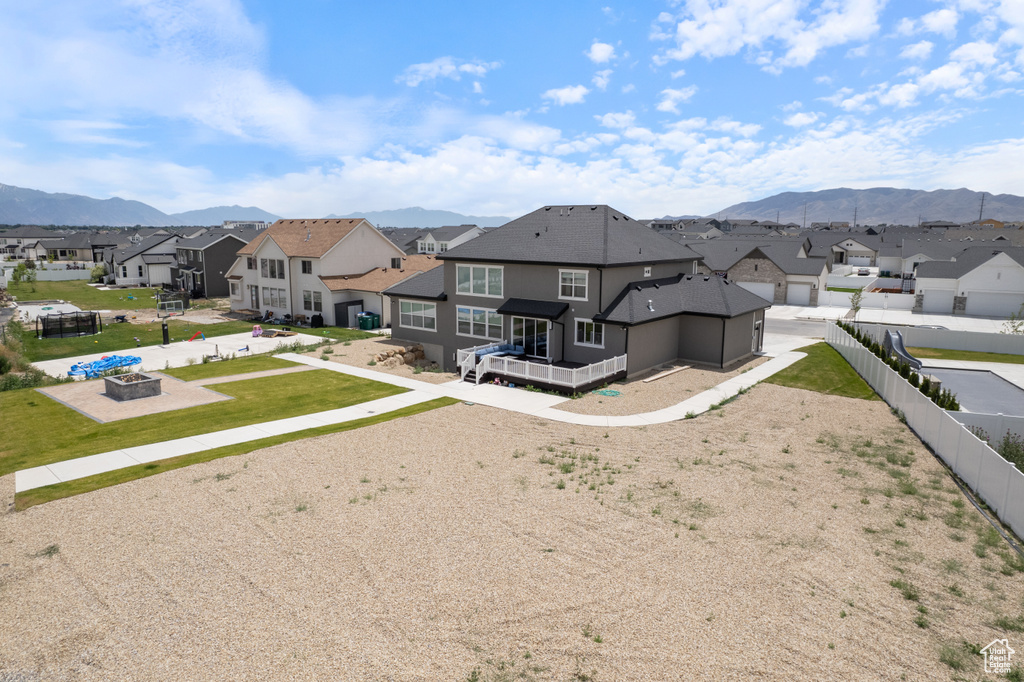 Rear view of house with a fire pit, a residential view, a mountain view, and a fenced backyard