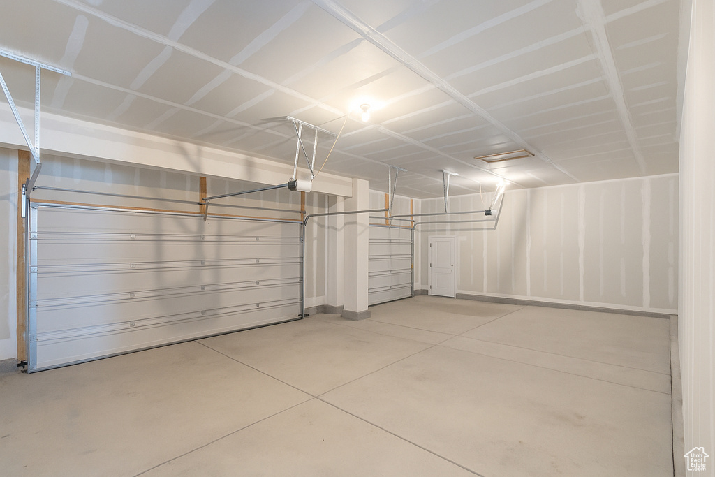 Garage with a garage door opener and baseboards