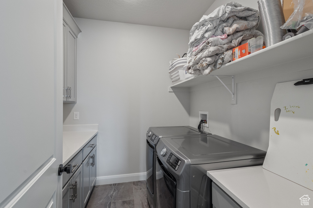 Washroom featuring washing machine and clothes dryer and cabinet space