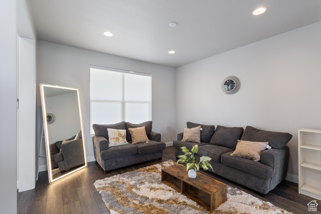 Living room with dark wood finished floors and recessed lighting