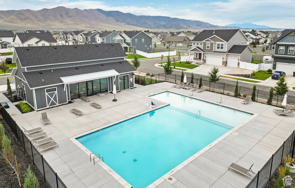 Community pool featuring a residential view, a mountain view, and a patio area