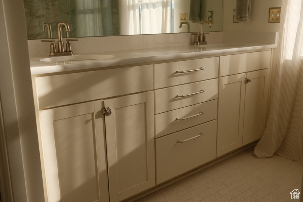 Full bathroom featuring double vanity and tile patterned floors