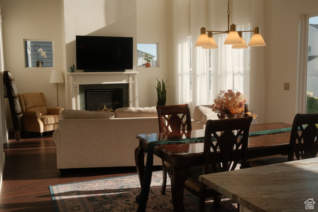 Dining area with dark wood-style floors and a glass covered fireplace