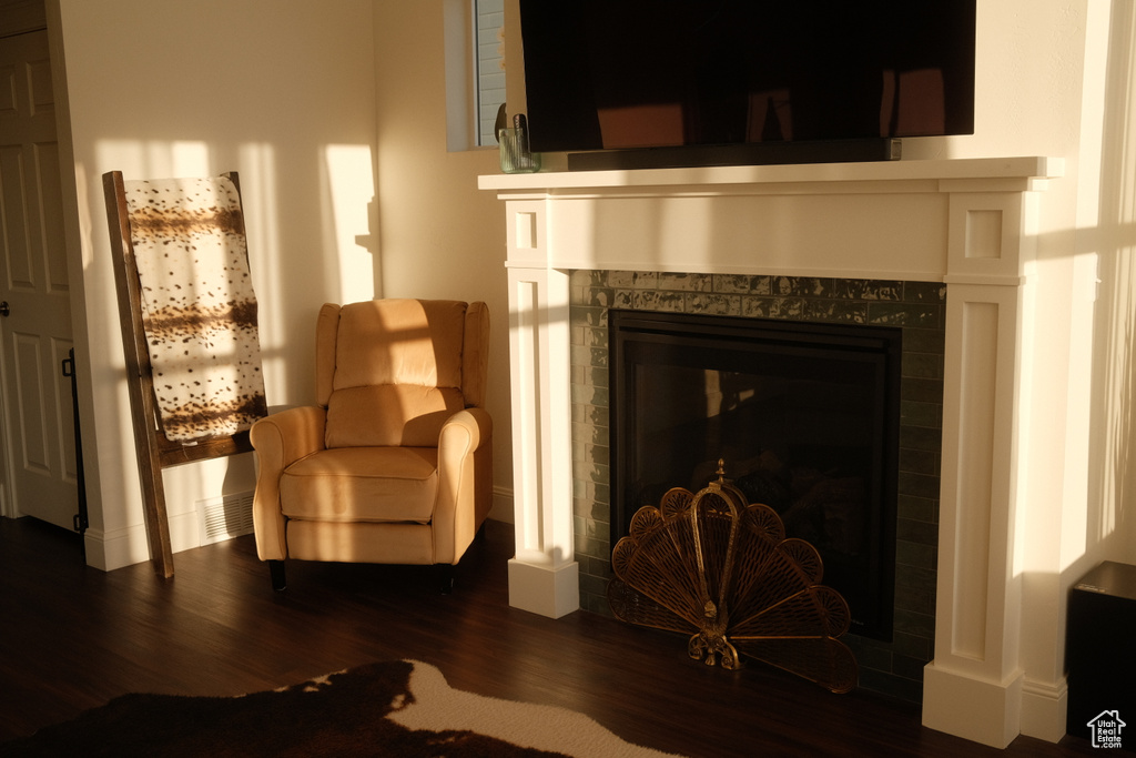 Sitting room with dark wood-type flooring and a fireplace