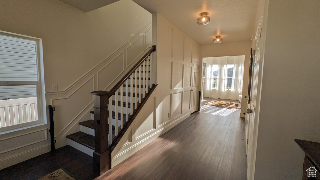 Staircase featuring wood finished floors and a decorative wall